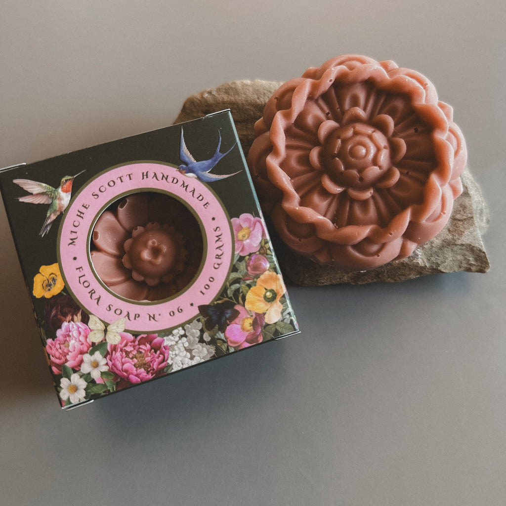 Handmade soap with floral packaging on a gray surface