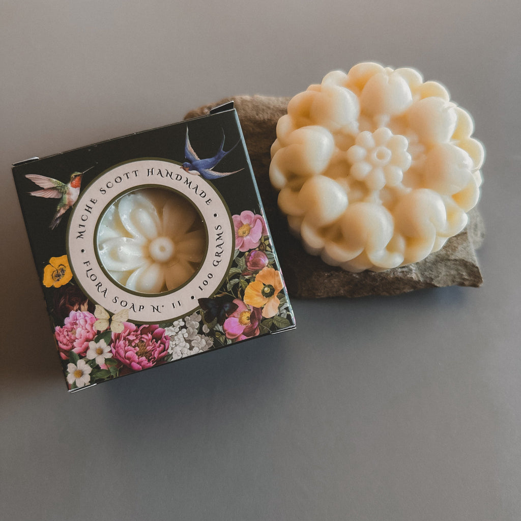 Handmade soap bar with decorative packaging on a gray surface