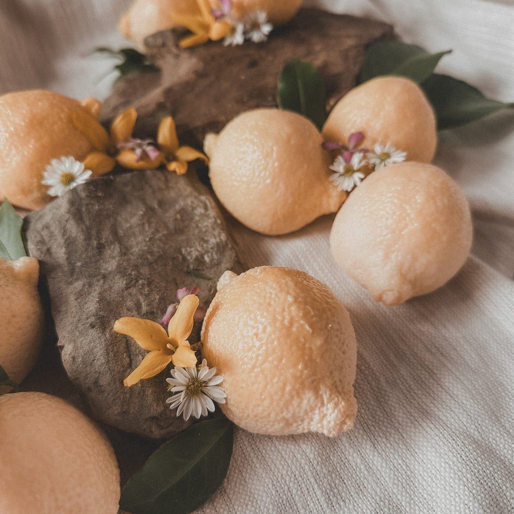 Oranges with flowers and leaves on a textured surface