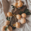 Decorative arrangement of lemons, flowers, and stones on a textured fabric background