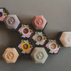 Hexagonal soaps with floral designs and different colors on a gray background